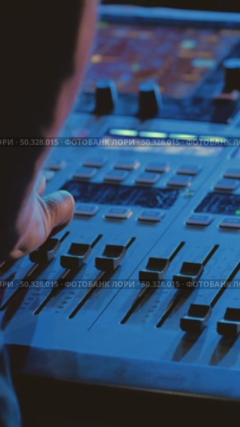 Close-up of a mixing console with various sliders and buttons. The sound engineer's hand adjusts the level and controls the recording process. Стоковое видео, видеограф Воловодов Владимир / Фотобанк Лори