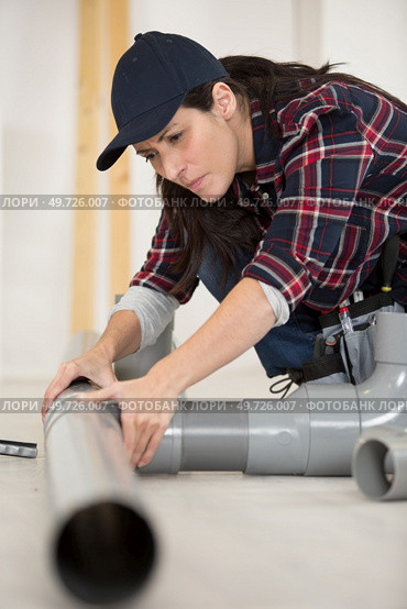 close up of concetrated female plumber at work. Стоковое фото, агентство Ingram Publishing / Фотобанк Лори
