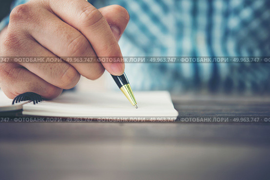 Close up of man hand writing in notebook with pen. Стоковое фото, агентство Ingram Publishing / Фотобанк Лори