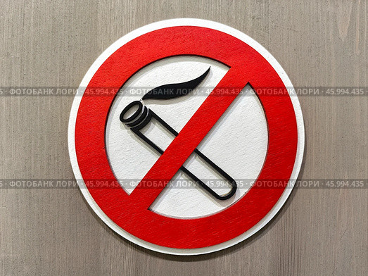 Close up of no smoking sign displayed on a wooden wall emphasizing the importance of a smoke-free environment. Стоковое фото, фотограф Александра Селина / Фотобанк Лори