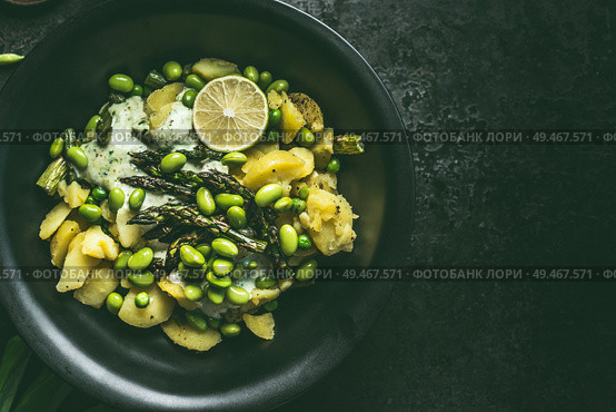 Close up of potatoes and green asparagus salad with edamame soybeans in black bowl, top view with copy space. Healthy vegetarian food concept. Стоковое фото, агентство Ingram Publishing / Фотобанк Лори