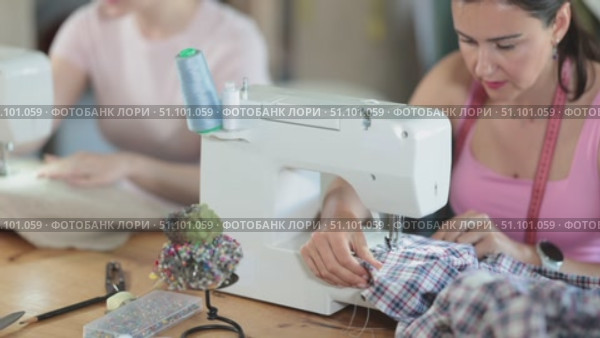 Close-up of woman seamstress sews on sewing machine. Стоковое видео, видеограф Яков Филимонов / Фотобанк Лори