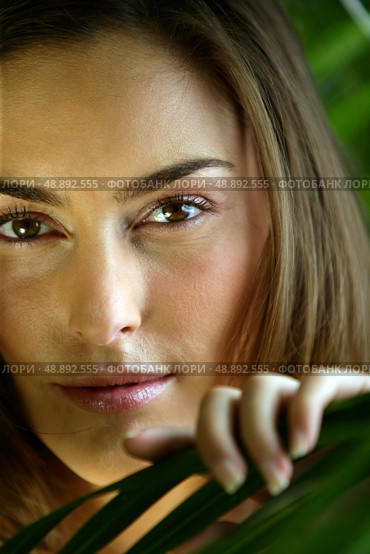 Close-up of woman touching leaf. Стоковое фото, агентство Ingram Publishing / Фотобанк Лори