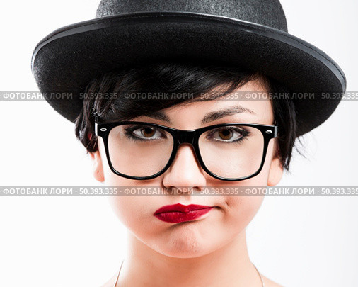 Close-up portrait of a beautiful girl bored with something, wearing a hat and nerd glasses. Стоковое фото, агентство Ingram Publishing / Фотобанк Лори