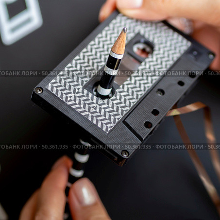 close up shot person repairing cassette tape with pencil. Стоковое фото, агентство Ingram Publishing / Фотобанк Лори