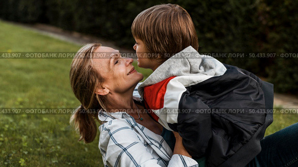 close up smiley woman holding kid. Стоковое фото, агентство Ingram Publishing / Фотобанк Лори