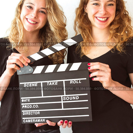 close up smiling wins sister holding clapperboard hands. Стоковое фото, агентство Ingram Publishing / Фотобанк Лори