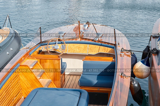 Close-up view of a relaxation area on the open teak deck of an expensive motorboat at sunny day, Monaco yacht show, large boat exhibition, wealth life, table and chairs. Стоковое фото, фотограф Vladimir Drozdin / Фотобанк Лори