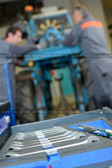 Closeup of set of spanners, mechanics in background. Стоковое фото, агентство Ingram Publishing / Фотобанк Лори
