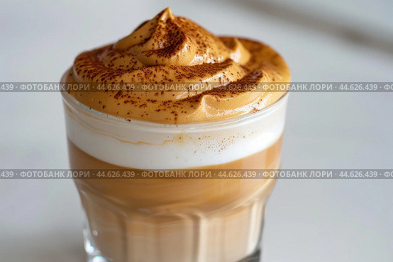 Closeup view of a homemade dalgona coffee with a frothy top in a clear glass. Стоковое AI-изображение, AI-художник Иван Рябоконь / Фотобанк Лори