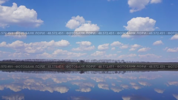 Clouds are reflected in smooth water of lake - timelapse, 4k. Стоковое видео, видеограф Михаил Коханчиков / Фотобанк Лори