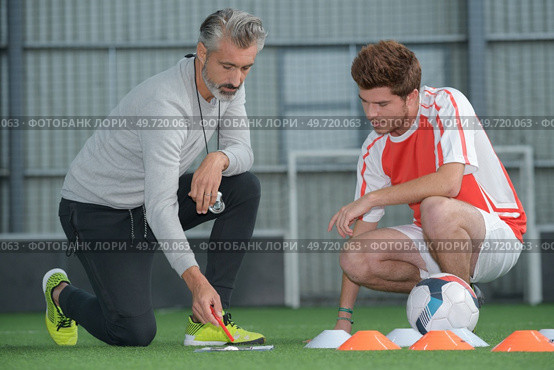 coach talking tactics with young foorball palyer. Стоковое фото, агентство Ingram Publishing / Фотобанк Лори