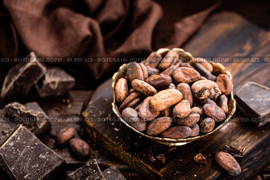 Cocoa beans and chocolate on wooden background. Стоковое фото, агентство Ingram Publishing / Фотобанк Лори