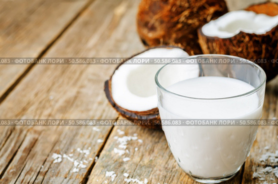 coconut milk and coconuts on a dark wood background. the toning. selective focus. Стоковое фото, агентство Ingram Publishing / Фотобанк Лори