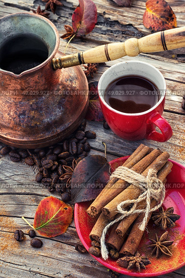 Coffee in the fall. Stylish porcelain Cup of coffee on  background decorated with spices and strewn with autumn leaves. Стоковое фото, агентство Ingram Publishing / Фотобанк Лори
