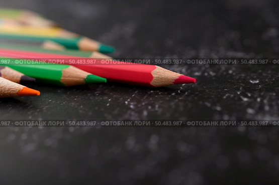 colorful crayon pencils with triangle shape on black background with copy space. Selective focus. Стоковое фото, агентство Ingram Publishing / Фотобанк Лори