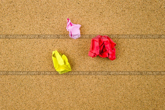 Colorful crumpled papers over cork background. Стоковое фото, фотограф Constantin Stanciu / Smarterpix / Фотобанк Лори