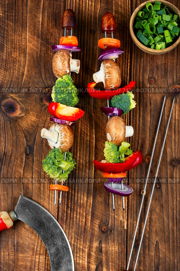 Colorful grilled summer seasonal vegetables skewers on wooden rustic background. Preparation of vegetable kebabs. Vegan food concept.. Uncooked BBQ Vegetable Skewers. Стоковое фото, агентство Ingram Publishing / Фотобанк Лори