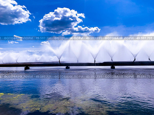 Colorful sight: cooling fountains of the Atomic Station, Heat of a power plant against a background of white clouds and blue sky.. Colorful sight: cooling fountains of the Atomic Station, Heat of a power plant against a background of white clouds, blue sky. Стоковое фото, агентство Ingram Publishing / Фотобанк Лори