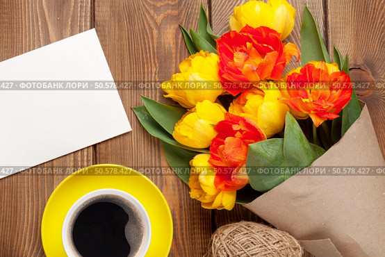 Colorful tulips bouquet, blank greeting card and coffee cup on wooden table. Стоковое фото, агентство Ingram Publishing / Фотобанк Лори