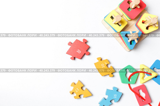 colorful wooden puzzle pieces and wooden puzzle toy, sorter on white background with space. Стоковое фото, фотограф Bogdanova Mariia / Фотобанк Лори