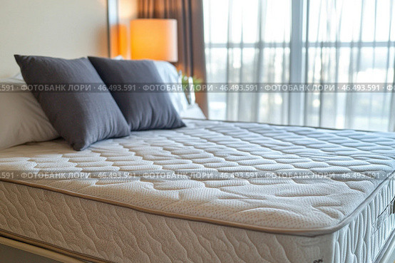 Comfortable mattress with pillows in bedroom interior design showing hotel room or apartment suite. Стоковое AI-изображение, AI-художник Юрий Поздников / Фотобанк Лори