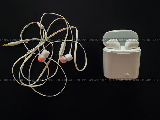 Comparison between tangled wired headphones versus wireless earphones for music listening. Pros and cons, opposite contrary. Technology development tendencies, human entertainment conveniences concept. Стоковое фото, агентство Ingram Publishing / Фотобанк Лори