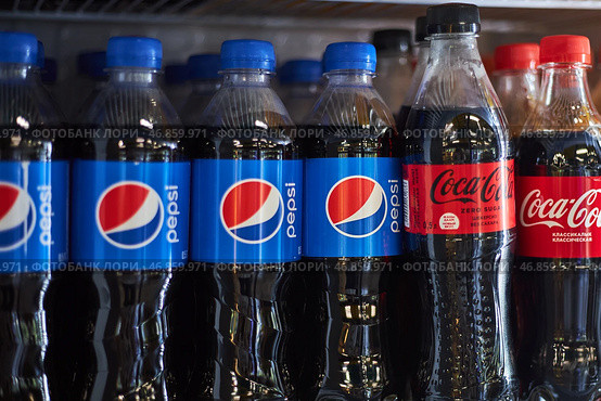 Competing brand plastic soda bottles on one shelf at supermarket. Pepsi and Coca Cola. Bishkek, Kyrgyzstan - 26 May 2023. Редакционное фото, фотограф Екатерина Якименко / Фотобанк Лори