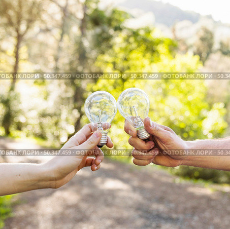 concept clinking bulbs hands nature. Стоковое фото, агентство Ingram Publishing / Фотобанк Лори