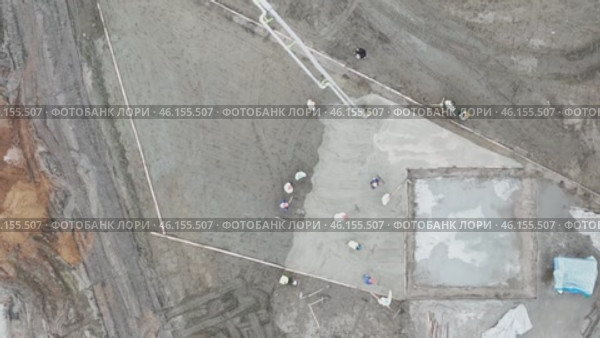 Concrete works from a top view by a quadcopter. Concrete workers are working on a construction site. Стоковое видео, видеограф Скрипачев Антон / Фотобанк Лори