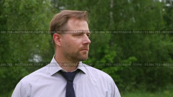 Confident Businessman in Natural Setting. Man stands in front of lush green backdrop. Remote working. Portrait of happy mid adult male wearing formal clothes, shirt and tie, glasses. Find inspiration. Стоковое видео, видеограф Марина Демидюк / Фотобанк Лори