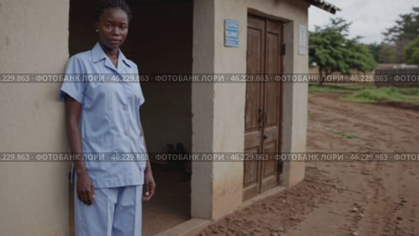 Confident nurse standing outside rural clinic. Стоковое видео, видеограф Данил Руденко / Фотобанк Лори
