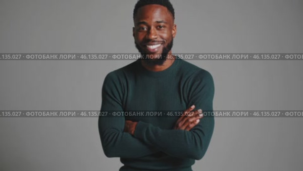Confident professional posing with folded arms on gray background. Стоковое видео, видеограф Данил Руденко / Фотобанк Лори