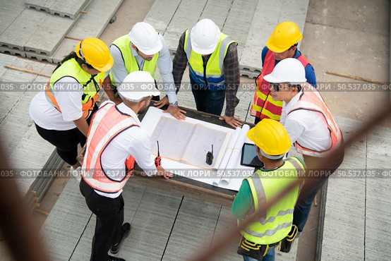 Construction engineers, architects, and foremen form a group. Participate in a meeting to plan new construction projects. Стоковое фото, агентство Ingram Publishing / Фотобанк Лори