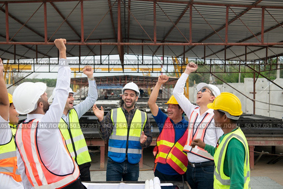 Construction engineers, architects, and foremen form a group. Participate in a meeting to plan new construction projects. Cheers to express happiness that the event was successfully accomplished. Стоковое фото, агентство Ingram Publishing / Фотобанк Лори