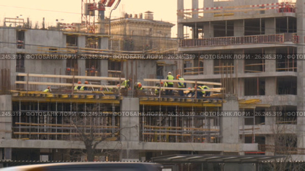 Construction site in the evening. The brigade makes the embedded elements of metal structures. Beautiful sunny evening. Стоковое видео, видеограф Игорь Усачев / Фотобанк Лори