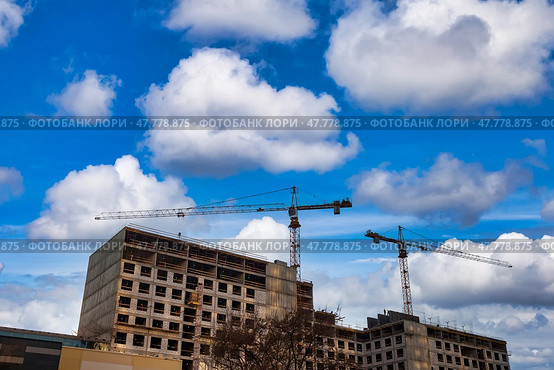 Construction Site Under a Clear Sky With Cranes and Scaffolding Working Tirelessly. Стоковое фото, фотограф Aleksandr Golubev / Фотобанк Лори
