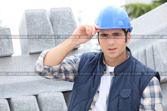 Construction worker in a hardhat next to concrete kerbing. Стоковое фото, агентство Ingram Publishing / Фотобанк Лори