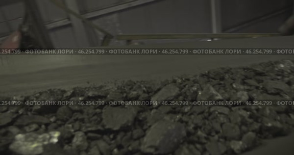 Conveyor belt with coal shooting in slow motion. Close-up of coal on conveyor belt. Conveyor belt with ore. Machine for loading coal. Tape conveyor used to load Anthracite mining coal mine factory. Стоковое видео, видеограф Сергей Тимофеев / Фотобанк Лори