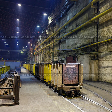 Copper production at the metallurgical plant. Metal sheets on trolleys. Industrial narrow gauge railway in a large factory room. Norilsk, Krasnoyarsk Region, Russia. Редакционное фото, фотограф Андрей Степанов / Фотобанк Лори