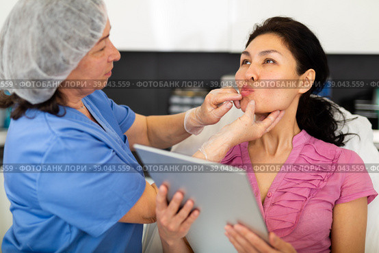 Cosmetologist consulting woman before procedures for lip augmentation. Стоковое фото, фотограф Яков Филимонов / Фотобанк Лори