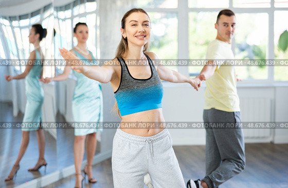 Couple in comfortable sports clothes learns boogie woogie dancing during individual lesson. Стоковое фото, фотограф Яков Филимонов / Фотобанк Лори