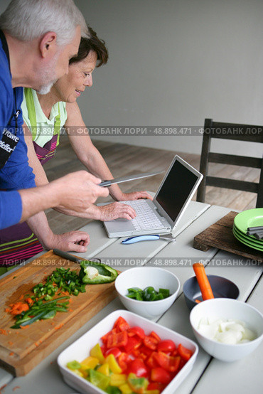 Couple looking at a recipe on-line. Стоковое фото, агентство Ingram Publishing / Фотобанк Лори