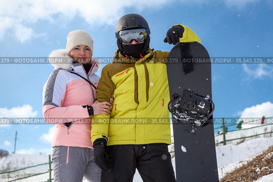 Couple of snowboarders, portrait with snowboard, persons wearing ski equipment. Стоковое фото, фотограф Кекяляйнен Андрей / Фотобанк Лори
