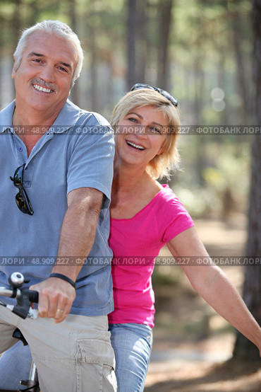 Couple riding a bike. Стоковое фото, агентство Ingram Publishing / Фотобанк Лори