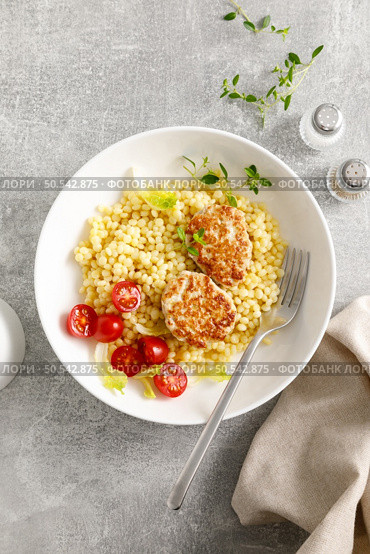 Couscous with chicken patties, cutlets and tomatoes, top down view. Стоковое фото, агентство Ingram Publishing / Фотобанк Лори