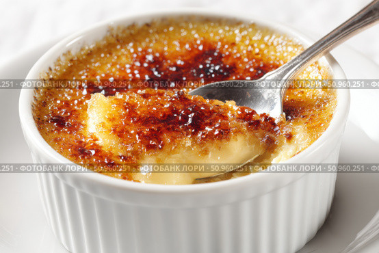 Creme brulee. dessert with caramel crust. Elegant Gourmet Dessert with Caramelized Sugar Crust. French vanilla cream. Eating Creme Brulee with Spoon. Cracking caramel. Delicious Sweet. Catalan cream. Стоковое AI-изображение, AI-художник Марина Демидюк / Фотобанк Лори