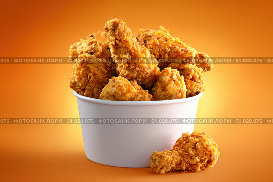 Crispy chicken on a yellow orange color background. Bucket overflowing with golden Fried Chicken Strips. Street food. Coated batter southern style chicken drumsticks and pieces. BBQ Feast. Nuggets. Стоковое AI-изображение, AI-художник Марина Демидюк / Фотобанк Лори