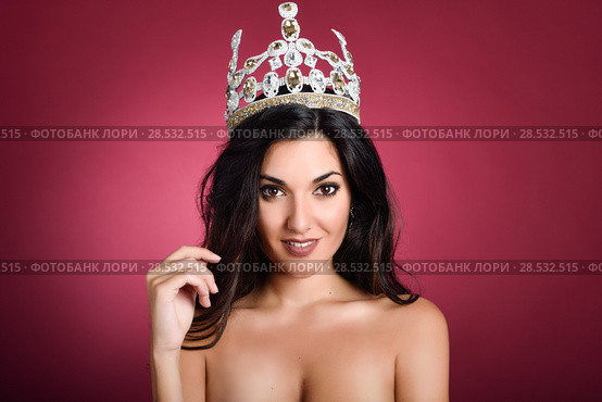 Crowned woman like miss of beauty looking at camera isolated on red wine background. Girl wearing crown, studio shot. Стоковое фото, фотограф Javier Sánchez Mingorance / Ingram Publishing / Фотобанк Лори