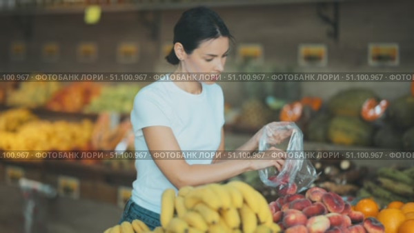 Customer prepares to weigh the fruit before buying. Стоковое видео, видеограф Яков Филимонов / Фотобанк Лори